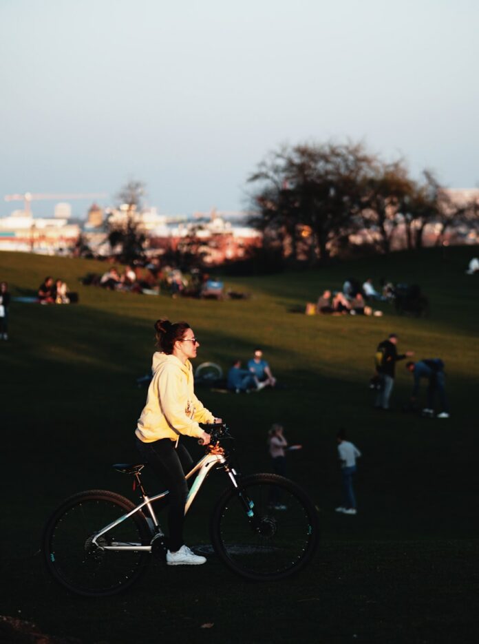 Photo by dominik hofbauer man in white shirt riding bicycle during daytime