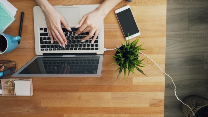 Photo by Vitaly Gariev a person typing on a laptop on a wooden table