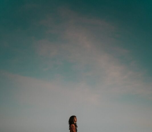 지속적인 두통의 원인과 해결책: 전문가의 조언 A person sitting on top of a large rock