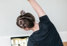 헬스장 vs 홈트: 어떤 운동이 더 효과적일까? woman in black t-shirt and black pants lying on black yoga mat