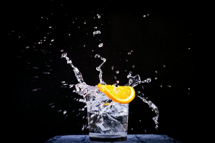 Photo by Thao LEE splash of water in drinking glass with sliced lemon