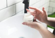 “피부 화장 안 먹는 이유, 속건조 때문일지도 몰라요” person holding white and black plastic bottle