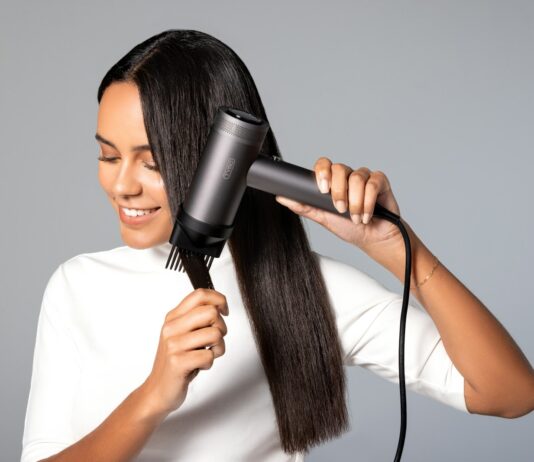‘건강한 두피와 윤기나는 모발’…일상 속 실천하는 헤어 루틴이 인기 a woman blow drying her hair with a hair dryer