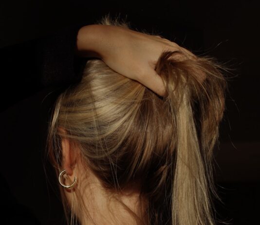 두피 청결부터 스트레스 관리까지, 건강한 머릿결을 위한 생활습관이 주목받는다 a woman with her hair in a bun