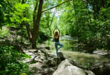필라테스, 내 몸과 마음을 단련하는 생활 속 건강 습관으로 주목 woman in blue tank top and blue leggings standing on gray rock near river during daytime